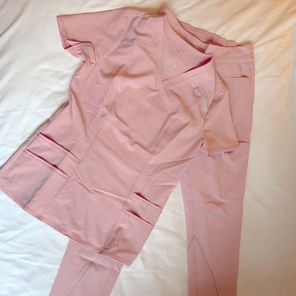 Jaanuu light pink scrub set. Bottoms- slim straight leg. Top- 4 pocket v neck.